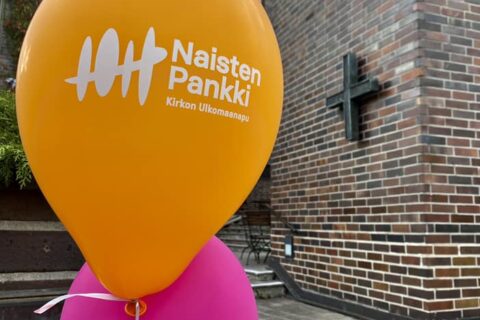 Naisten pankin värikkäitä ilmapalloja, taustalla Hamprin merimieskirkon tiiliseinä