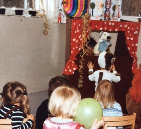 80-luvulta oleva kuva lapsista, jotka katselevat nukketeatteria